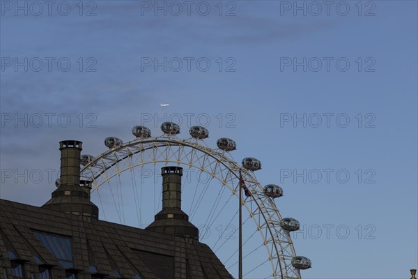 Airbus A319-100 aircraft of British airways in flight over the pods of the London Eye or Millennium Wheel, London, England, United Kingdom, Europe