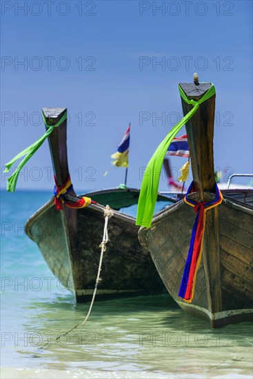 Longtail boat, fishing boat, wooden boat, boat, decorated, tradition, traditional, faith, cloth, colourful, bay, sea, ocean, Andaman Sea, tropical, tropical, island, water, beach, beach holiday, Caribbean, environment, clear, clear, clean, peaceful, picturesque, sea level, climate, travel, tourism, paradisiacal, beach holiday, sun, sunny, holiday, dream trip, holiday paradise, paradise, coastal landscape, nature, idyllic, turquoise, Siam, exotic, travel photo, sandy beach, Krabi, Thailand, Asia