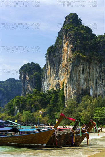 Longtail boats, boat, wooden boat, ferry boat, ferry, tourist ferry, transport, transpoLimestone cliffs at Railay Beach, limestone, limestone cliffs, travel, holiday, tourism, nature, natural landscape, Andaman Sea, climbing cliffs, mountain, rock, cliff, bizarre, sun, sunny, tropical, lagoon, sea, ocean, palm trees, holiday paradise, Siam, paradise, Asian, landscape, Krabi, Thailand, Asia