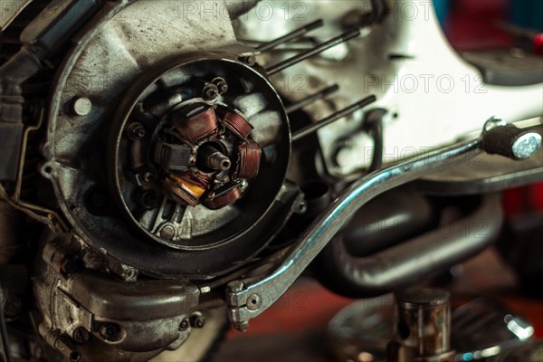 Close-up of a classic italian vintage scooter motorcycle engine's stator assembly in a workshop setting