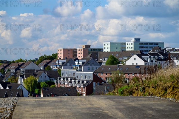 View of a city street with terraced houses under a partly cloudy sky, Wuelfrath, Mettmann, Bergisches Land, North Rhine-Westphalia