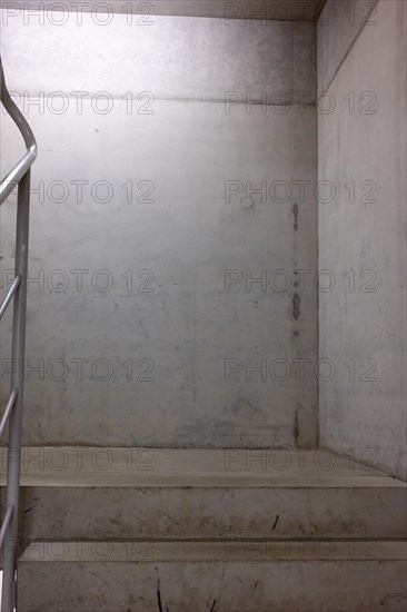 View of an empty stairwell with white concrete walls and steps