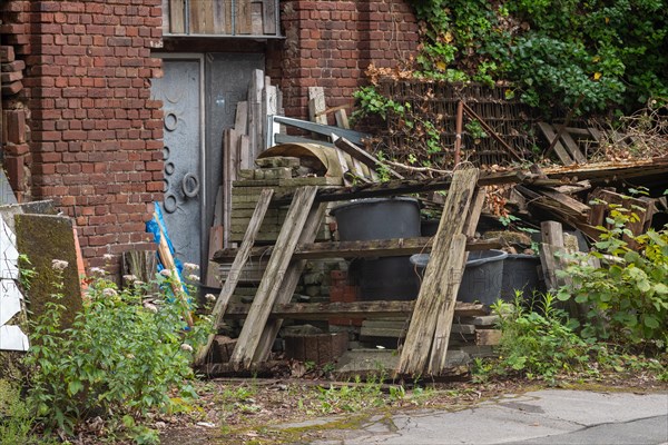 Pile of broken wood and scrap metal in front of a brick building