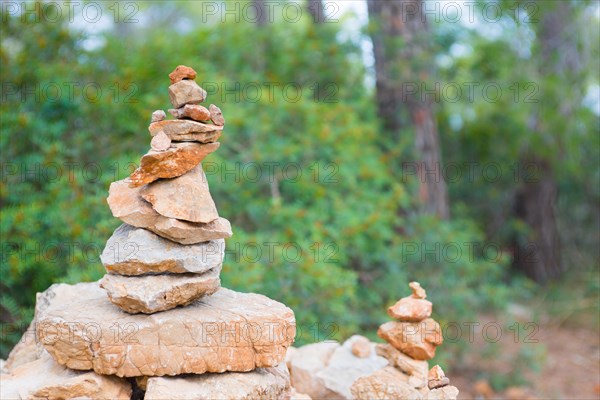 Carefully stacked, slightly red stones form a stone figure, cairn, waymark, marker in the forest, hiking trail from Sant Elm to the old watchtower Torre Cala Basset, balance, Mediterranean, Serra de Tramuntana, Majorca, Spain, Europe