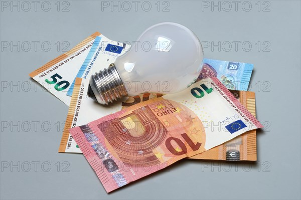 Banknotes and light bulbs, electricity costs