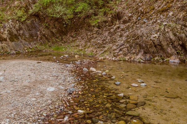 Clear waters flow gently over a pebble-covered riverbed, in South Korea