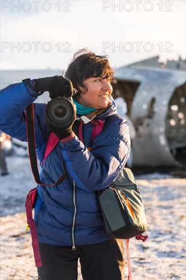 Portrait of adventurous photographer woman in winter in Iceland on the plane by Solheimasandur