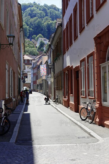 Narrow alley with orange-coloured houses and parked bicycles on a sunny day, Heidelberg, Baden-Wuerttemberg, Germany, Europe