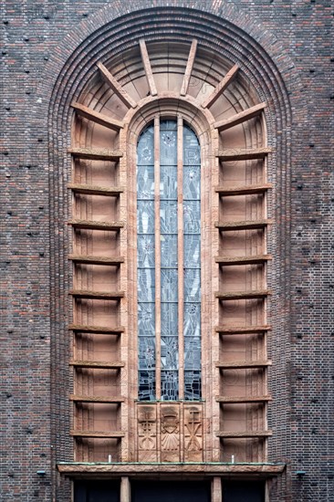 High Gothic church window surrounded by red bricks
