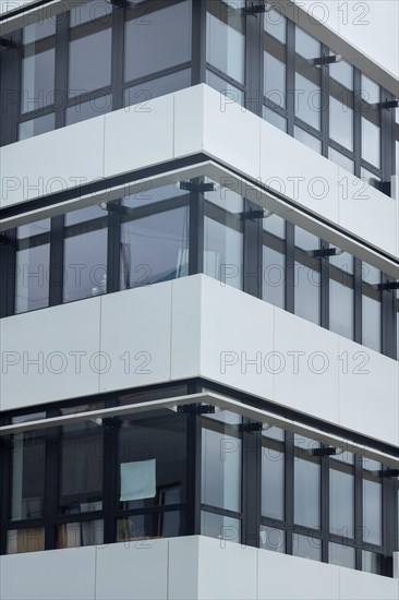 Contemporary building with glass windows and white facade in a geometric arrangement