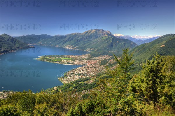 Panoramic View over an Alpine Lake Maggiore with mountain and Cityscape in a Sunny Summer Day over Locarno, Ticino, Switzerland, Europe