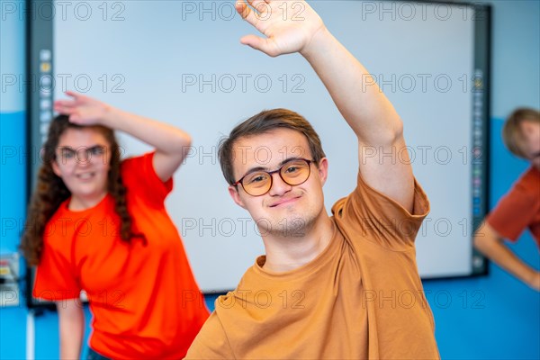 Man with down syndrome and mates in a gym standing stretching the back