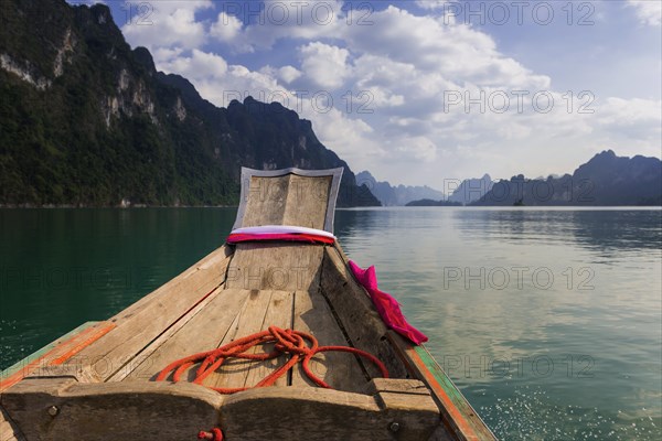Traditional longtail boat in front of limestone rocks in Cheow Lan Lake in Khao Sok National Park, nature, travel, holiday, lake, reservoir, landscape, rock, rock formation, attraction, rock face, water, tourism, boat trip, landscape, natural landscape, adventure holiday, active holiday, outdoor, excursion, boat trip, nature reserve, travel photo, Thailand, Asia