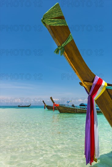 Longtail boat, fishing boat, wooden boat, decorated, tradition, traditional, faith, cloth, colourful, bay, sea, ocean, Andaman Sea, tropical, tropical, island, water, beach, beach holiday, Caribbean, environment, clear, clear, clean, peaceful, picturesque, sea level, climate, travel, tourism, paradisiacal, beach holiday, sun, sunny, holiday, dream trip, holiday paradise, paradise, coastal landscape, nature, idyllic, turquoise, Siam, exotic, travel photo, sandy beach, Phi Phi Island, Thailand, Asia