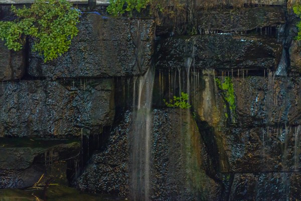 Close-up of water trickling down a mossy stone wall creating a serene atmosphere, in South Korea