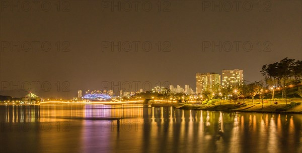 Night scene of lake side park in South Korea with city lights reflecting in the water in Sejeong, South Korea, Asia