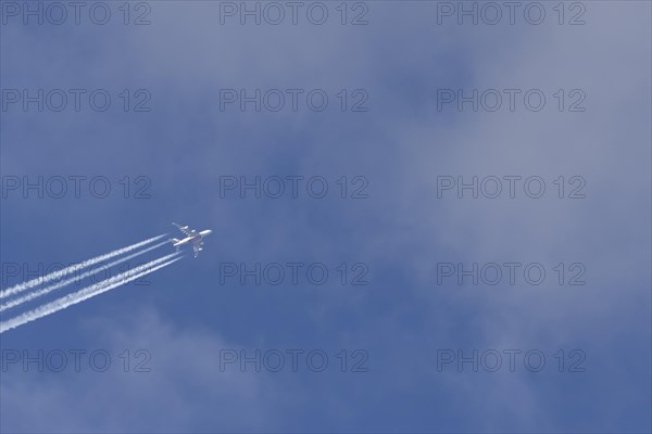 Airbus A380 aircraft in flight amongst white clouds with a contrail or vapour trail behind, England, United Kingdom, Europe