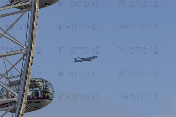 Aircraft of Korean airways in flight behind the pods of the London Eye or Millennium Wheel, London, England, United Kingdom, Europe