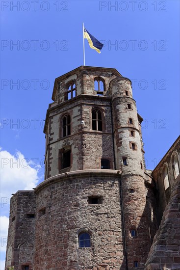 Tower of a castle (Heidelberg Castle), with round windows and a flag on a blue sky, Heidelberg, Baden-Wuerttemberg, Germany, Europe
