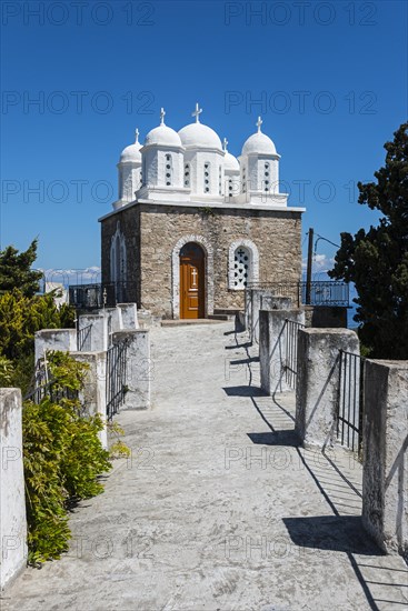 A white path leads to a church with blue domes under a bright blue sky, Byzantine fortress with nunnery, Holy Monastery of Timi Prodromos, Koroni, Pylos-Nestor, Messinia, Peloponnese, Greece, Europe