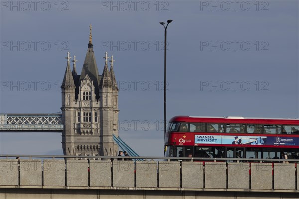 Red bus crosses over Tower Bridge, City of London, England, United Kingdom, Europe