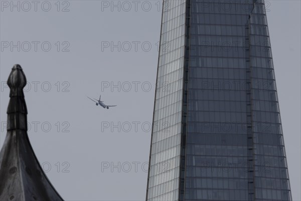 Airbus A319-100 aircraft of British airways in flight over The Shard city skyscraper building, London, England, United Kingdom, Europe