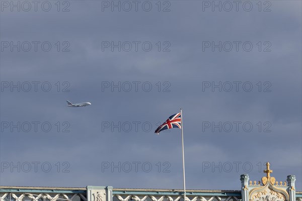 Airbus A380 aircraft of Emirates airlines in flight with a Union Jack flag on Tower Bridge in the foreground, London, England, United Kingdom, Europe