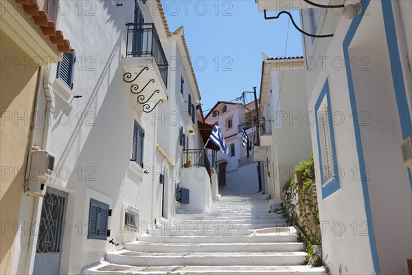 A sun-drenched alleyway with white houses and blue accents in Koroni, Pylos-Nestor, Messinia, Peloponnese, Greece, Europe
