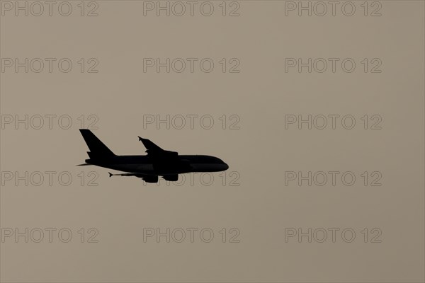 Airbus A380 aircraft in flight silhouette at sunset, England, United Kingdom, Europe