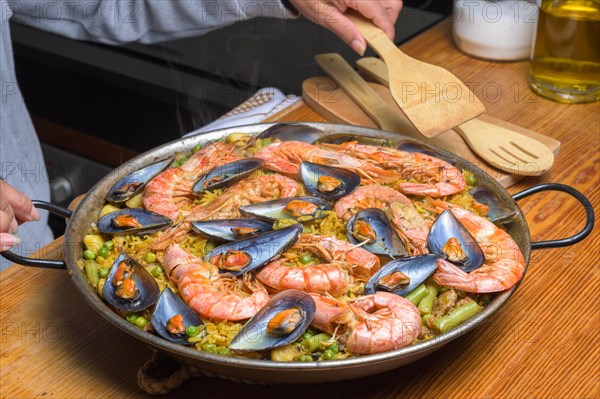 A traditional Spanish paella with shrimp and mussels in a rustic kitchen setup, typical Spanish cuisine, Majorca, Balearic Islands, Spain, Europe