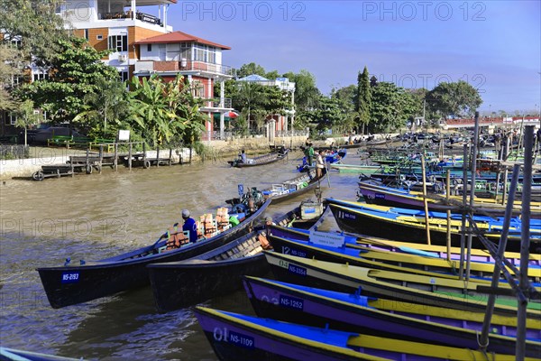 Riverbank with some boats and people, a small bridge in the background, Inle Lake, Myanmar, Asia