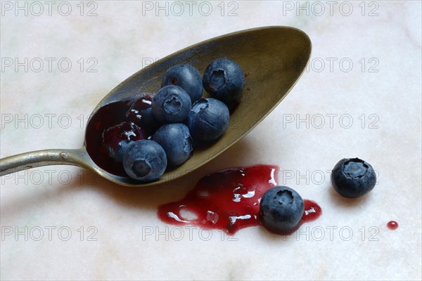 Blueberries and blueberry jam in spoons, blueberry
