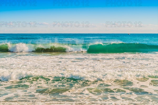 A curling wave in the ocean captures the essence of a sunny day, in South Korea