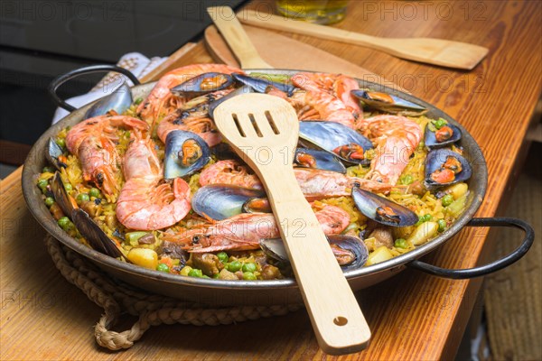 Seafood paella ready to be served with a wooden spatula on the table, typical Spanish cuisine, Majorca, Balearic Islands, Spain, Europe