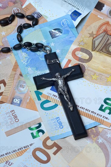 Crucifix and banknotes, church and money, church tax