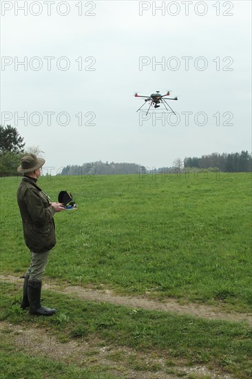 Hunter observes and controls flying drone during a hare (Lepus europaeus) census, Lower Austria, Austria, Europe