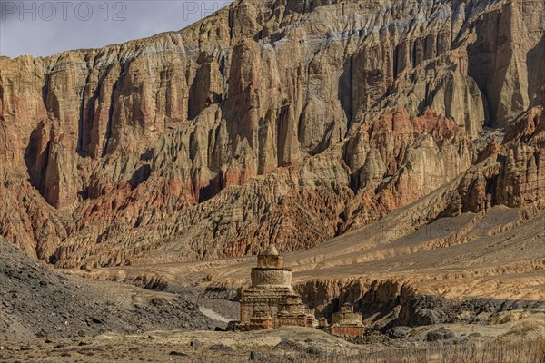Colourfully painted Buddhist stupa, before a colourful eroded mountain scenery, Kingdom of Mustang, Nepal, Asia
