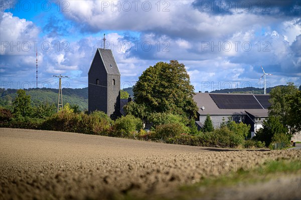Church stands next to a field under a cloudy blue sky, Windrather Tal, Velbert-Langenberg, Mettmann, Bergisches Land, North Rhine-Westphalia