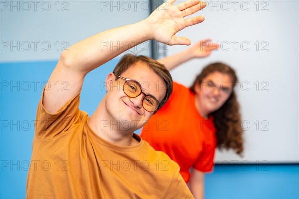 Man with down syndrome stretching and exercising with friends in the gym