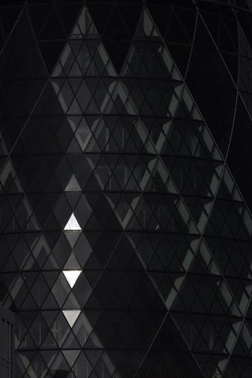 The Gherkin skyscraper building close up of window details with sunlight illuminating three triangle windows, City of London, England, United Kingdom, Europe
