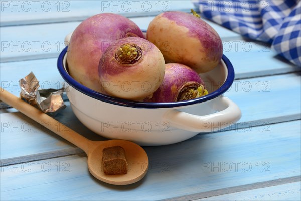 Purple turnips in pot and cooking spoon with stock cube, Brassica rapa