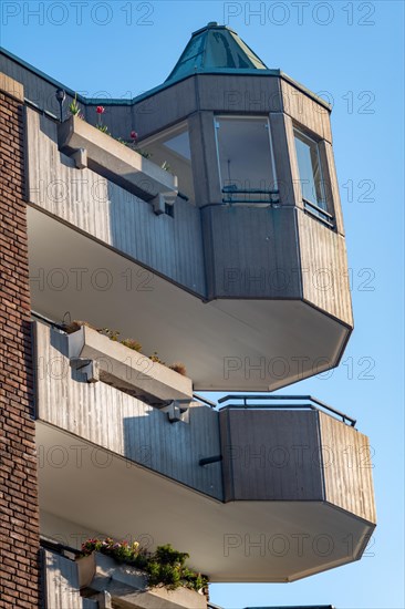 Balconies in a modern architecture on top of each other with blue sky in the background