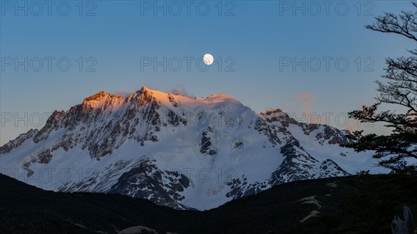 The snow-covered summit of Cerro Hermoso at sunrise with the moon, Perito Moreno National Park, Patagonia, Argentina, South America