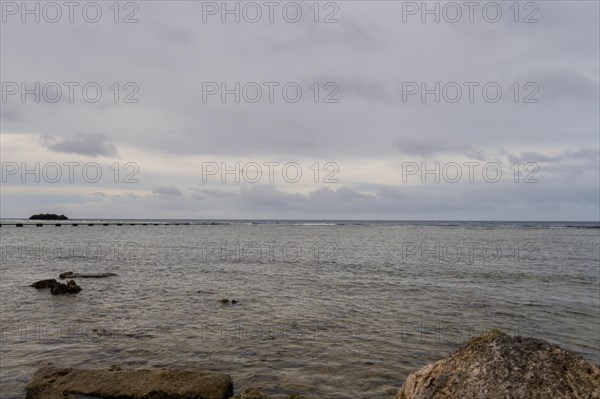 Seascape of the pacific ocean with a rocky shoreline taken in Guam on a cloudy day in Guam