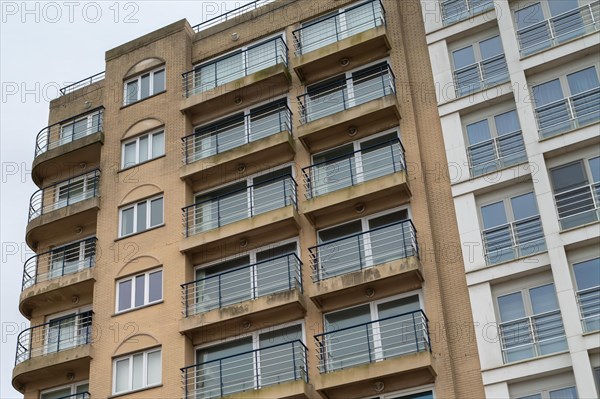 Multi-storey residential building with balconies and architectural decorations under a cloudy sky, Blankenberge, Flanders, Belgium, Europe