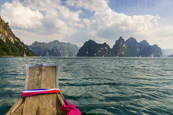 Traditional longtail boat in front of limestone rocks in Cheow Lan Lake in Khao Sok National Park, nature, travel, holiday, lake, reservoir, landscape, rock, rock formation, attraction, rock face, water, tourism, boat trip, landscape, natural landscape, excursion, boat trip, nature reserve, travel photo, Thailand, Asia