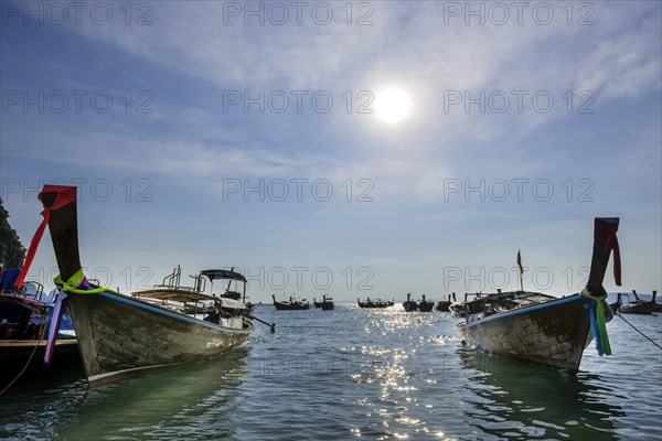 Longtail boat for transporting tourists, water taxi, taxi boat, ferry, ferry boat, fishing boat, wooden boat, boat, decorated, tradition, traditional, bay, sea, ocean, Andaman Sea, tropics, sun, backlight, tropical, water, travel, tourism, paradise, beach holiday, sun, sunny, holiday, dream trip, holiday paradise, paradise, nature, idyllic, turquoise, Siam, exotic, travel photo, Krabi, Thailand, Asia