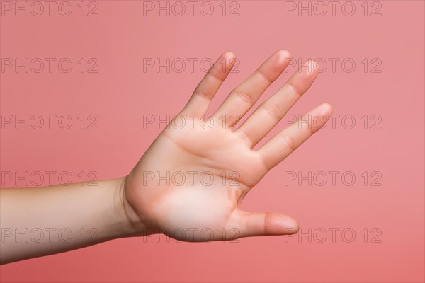 Woman's outstretched flat hand in defensive gesture in front of pink background. KI generiert, generiert AI generated