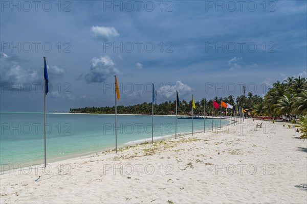 White sand beach with many flags, Bangaram island, Lakshadweep archipelago, Union territory of India