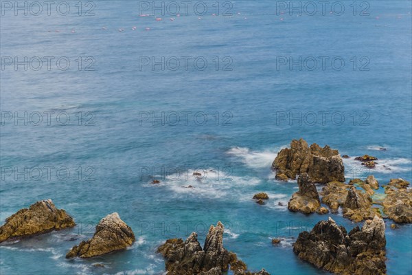 Pristine ocean waves crash against a rocky shoreline showcasing the rugged beauty of the coast, in South Korea